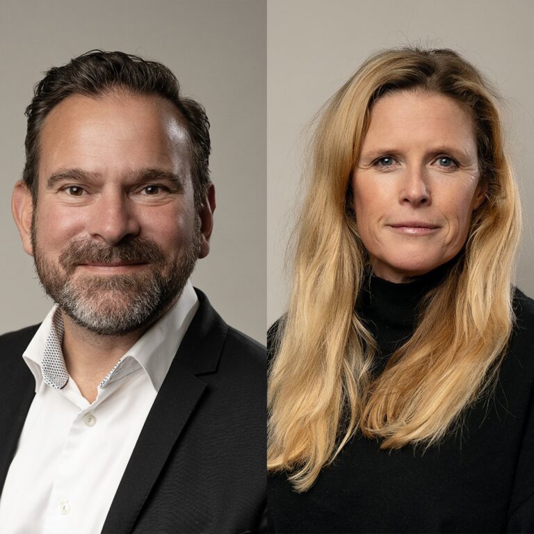 Man och kvinna poserar mot neutral bakgrund.