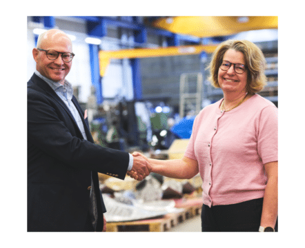 Man och kvinna skakar hand i fabrik
