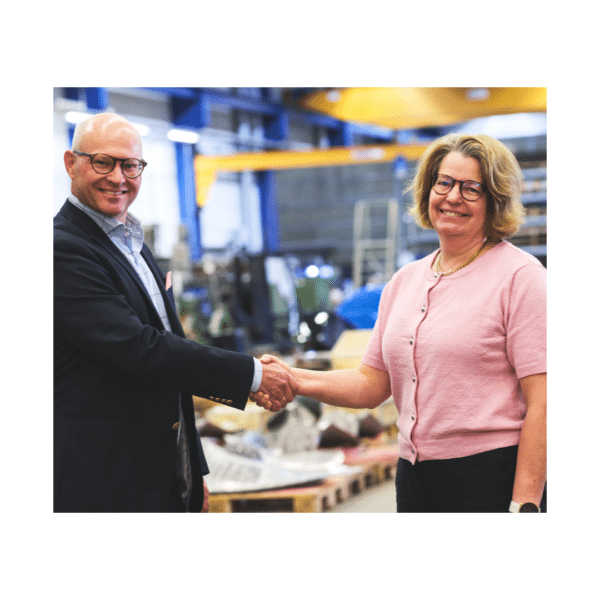 Man och kvinna skakar hand i fabrik