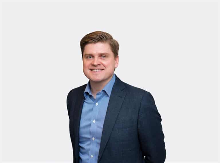 Man i kostym ler in i kameran