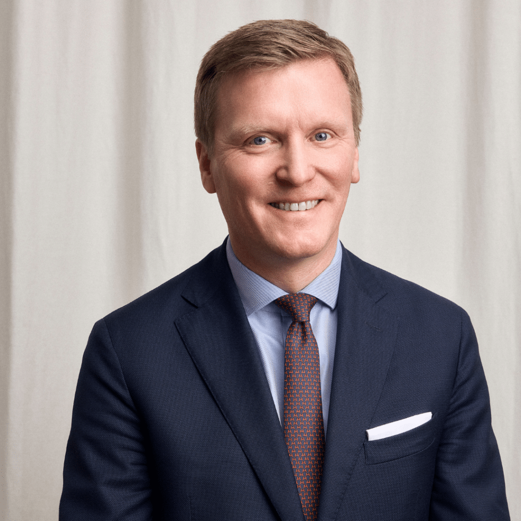 man i kostym ler in mot kameran