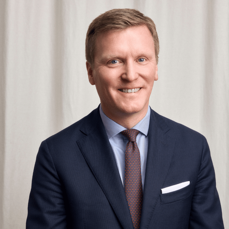 man i kostym ler in mot kameran