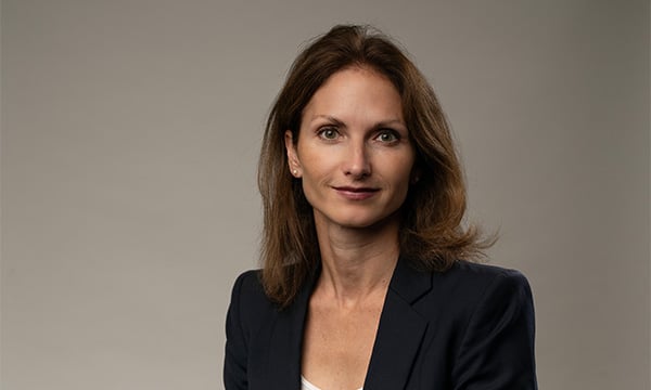 Kvinna i svart kavaj ler mot kameran