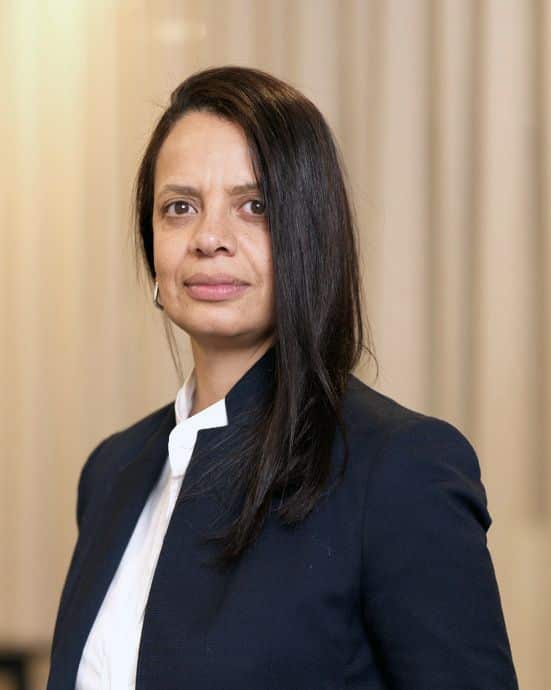 Kvinna i kostym ler mot kameran