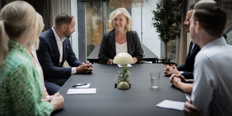 Människor sitter vid bordet under ett möte i kontor.