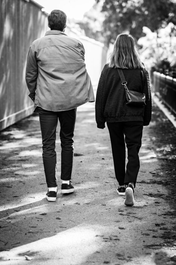 Två personer promenerar på stig i svartvitt foto.