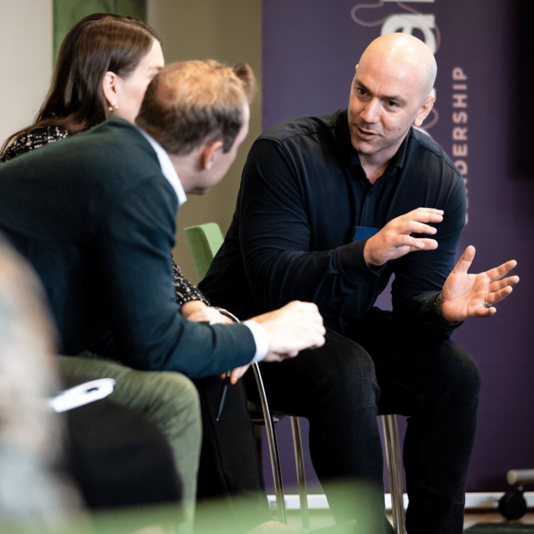 Tre personer diskuterar i ett ledarskapsprogram