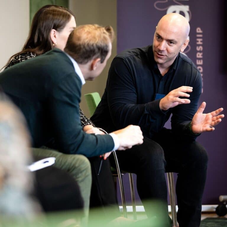 Tre personer på utbildning som diskuterar