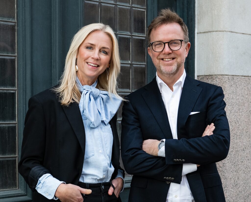 Porträtt framför en port med Petra Wigh & Lars Häggström på Novare