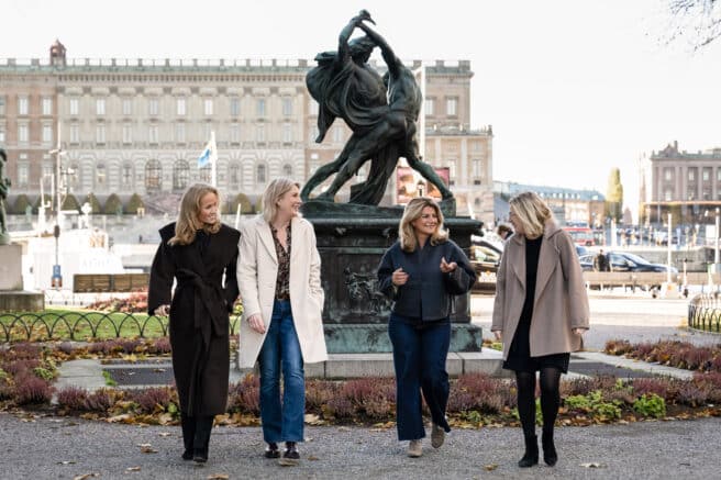 Gruppbild på fyra kvinnor framför en staty.