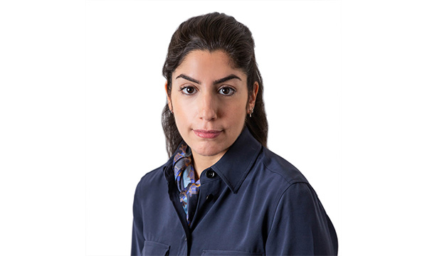 Person porträtteras; bär mörk skjorta; vit bakgrund.