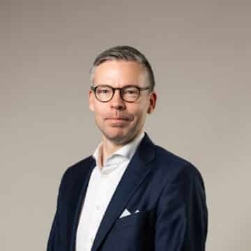 Glad kille med glasögon med vit skjorta och kavaj