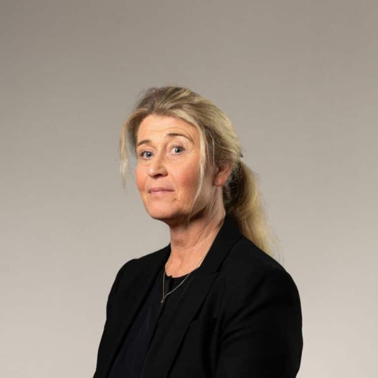 En blond kvinna med uppsatt hår i hästsvans i svart kavaj.