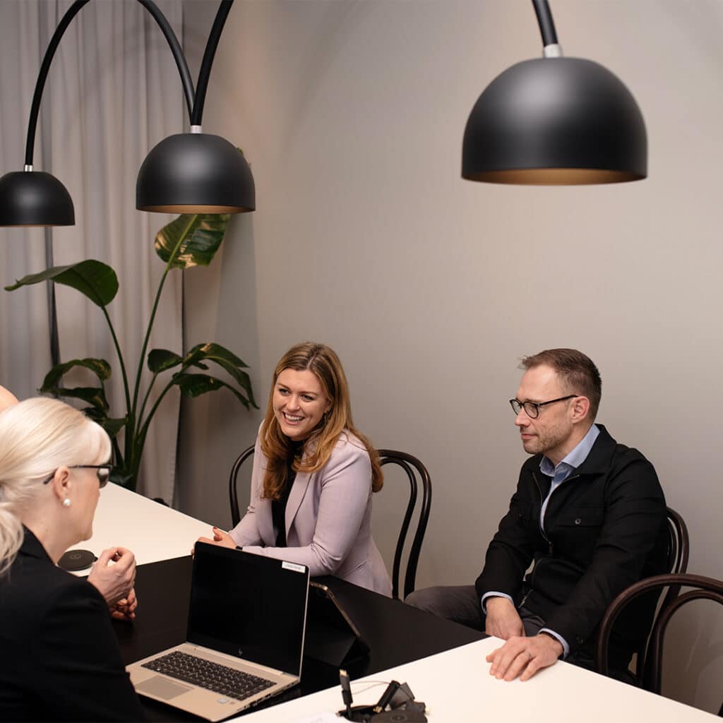 Två kvinnor och en man sitter i ett möte.