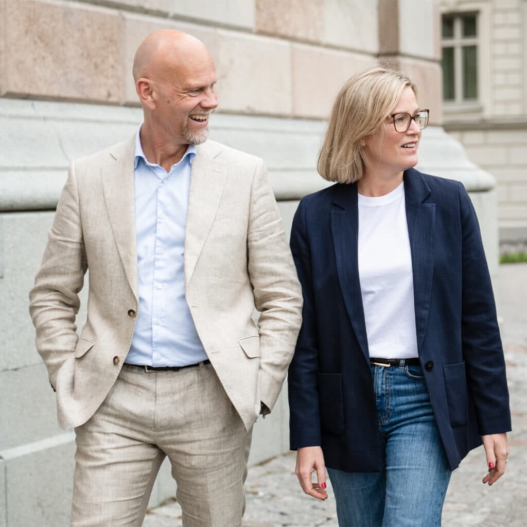 En man i beige kostym och en kvinna i blå kavaj.