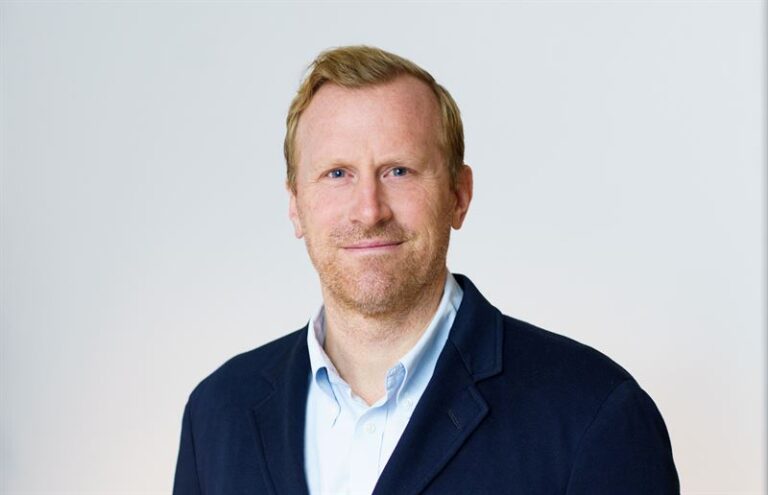 Man i skjorta och kavaj ler mot kameran