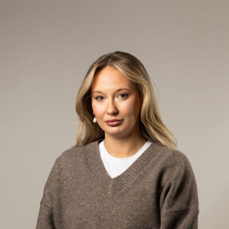 Leende kvinna med brun tröja.